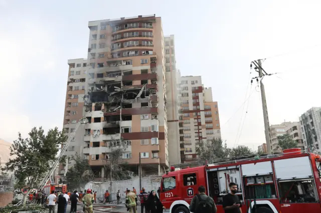 Bomberos trabajan en el lugar de un edificio dañado