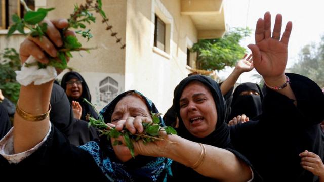Pessoas em luto durante o funeral dos bebês gêmeos palestinos Ossayd e Mohammad Abu Hmaid, a mãe e as três irmãs. Autoridades locais disseram que a família foi morta durante os ataques israelenses na Faixa de Gaza