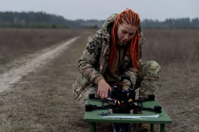युक्रेनच्या फायबर ऑप्टिक ड्रोनची तपासणी करताना युक्रेनची सैनिक