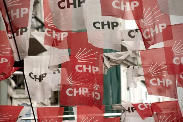 Kırmızı beyaz CHP bayrakları caddenin üzerinde sallanıyor. 
