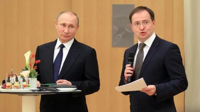 Володимир Мединський із мікрофоном щось говорить, поруч стоїть Володимир Путін