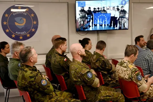 Oficiales militares escuchan una conferencia de prensa