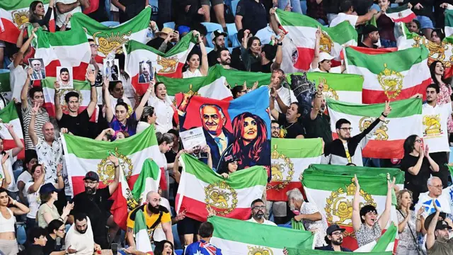 Iranski navijači na tribinama mašu zelenim, belim i crvenim zastavama
