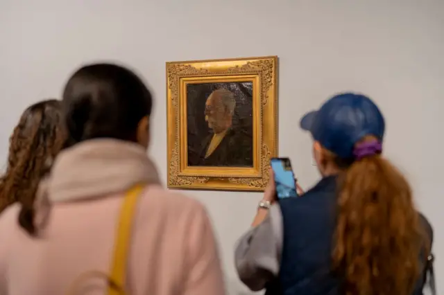 بازدیدکنندگان در مقابل پرتره معروفی که کمال‌الملک از خودش کشیده است