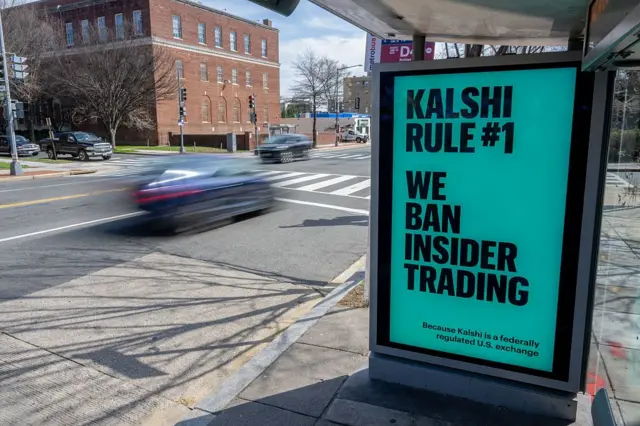 Reklama Kalshi na boku przystanku autobusowego; pogrubione czarne litery z napisem „Zasada Kalshi nr 1: zakazujemy handlu opartego na informacjach poufnych” na zielonym tle.