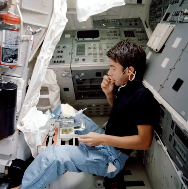 Un astronauta comiendo en el desaparecido transborador Columbia en 1982.