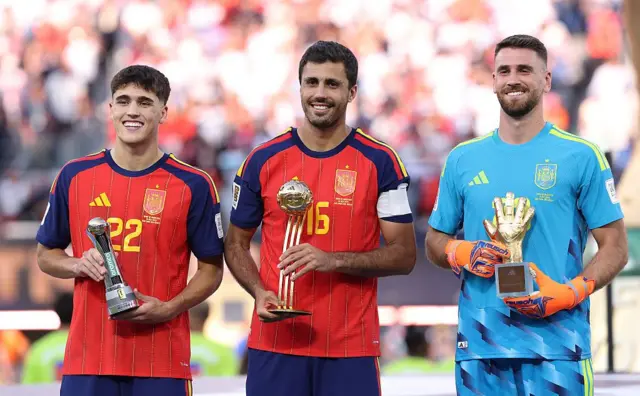 Pau Cubarsi (n° 22), Rodri (n° 16) et Unai Simon (n° 23), de l'équipe d'Espagne, posent avec leurs trophées à l'issue de la finale de la Coupe du monde de la FIFA 2026 opposant l'Espagne à l'Argentine, qui s'est déroulée le 19 juillet 2026 au New York New Jersey Stadium, à East Rutherford, dans le New Jersey.