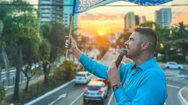 Homem brancovbet italiacimavbet italiaviaduto num por do sol segura um microfone e balança bandeira 