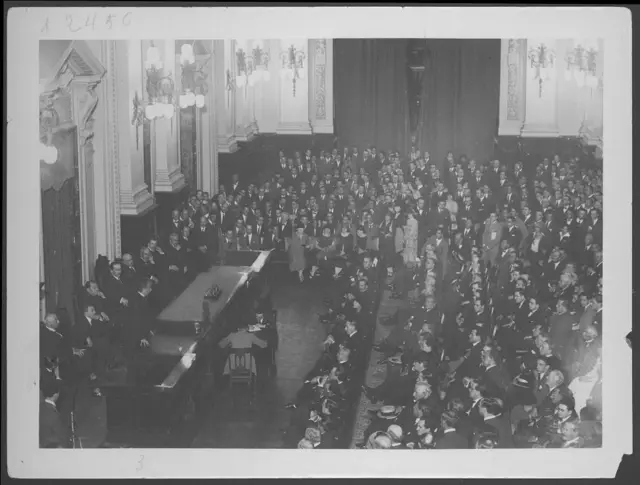 Un gran número de personas sentadas en un gran salón