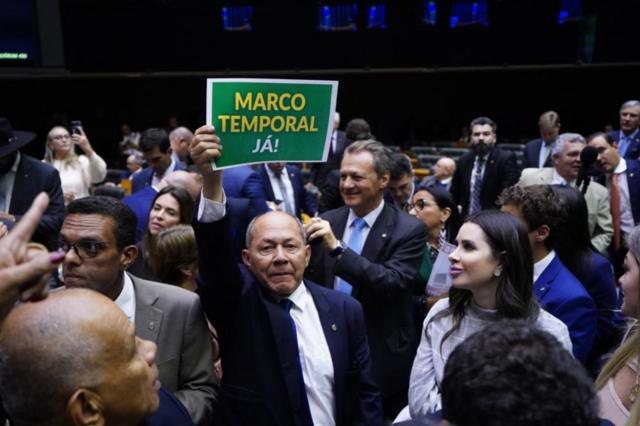 Deputado levantando cartaz que diz: 'Marco temporal já!'