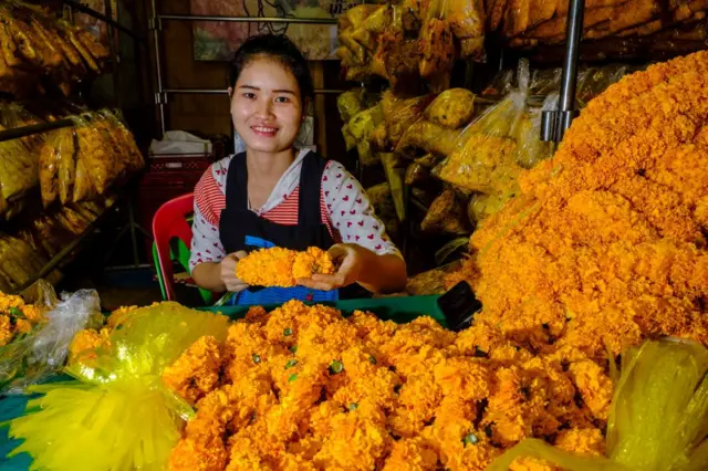 Một phụ nữ bán tại cửa hàng hoa ở Bangkok