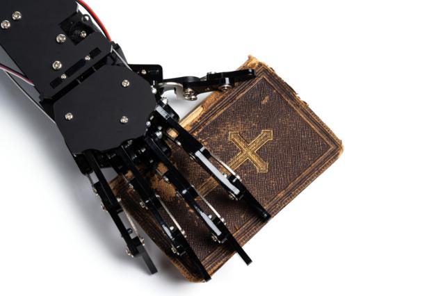 Mão robótica segurando a Bíblia