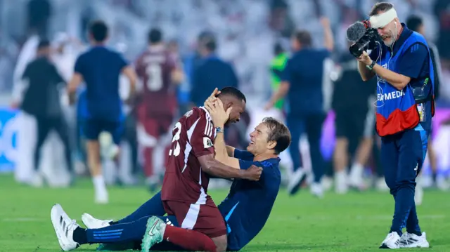 المدافع القطري عاصم ماديبو يحتفل مع مدرب الإسباني للمنتخب القطري جولين لوبيتيغي