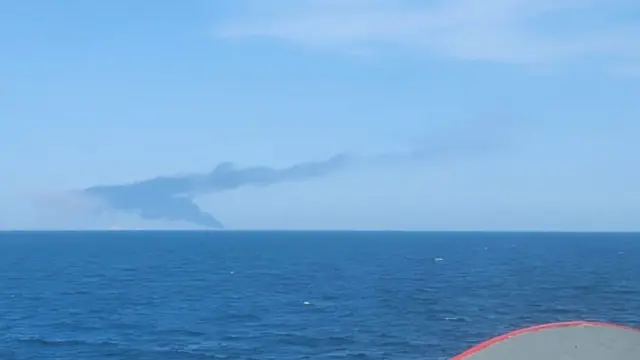 црни сим се уздиже на хоризонту где се види море 