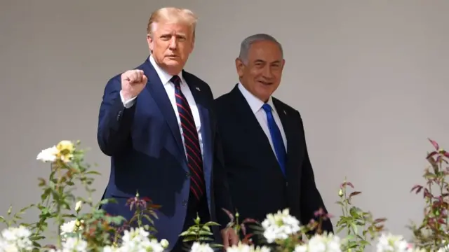 O presidente eleito dos Estados Unidos, Donald Trump, com o punho direito cerrado e olhando para a câmera, ao lado do primeiro-ministro israelense, Benjamin Netanyahu