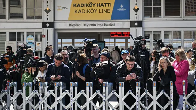 Uluslararası basın görüşme beklentisiyle Dolmabahçe'de toplanmış. Fotoğrafta çok sayıda gazeteci var. Kimi yayın yapıyor kimi notlarına bakıyor.