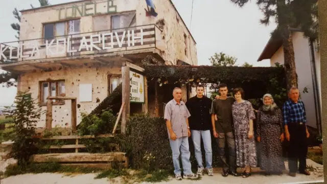 Edis Kolar y su familia frente a la casa de sus abuelos y la entrada al túnel