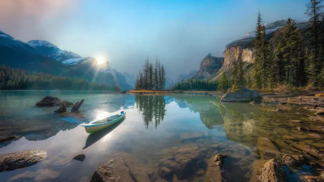 Гірське озеро з прозорою водою, на ньому порожній човен