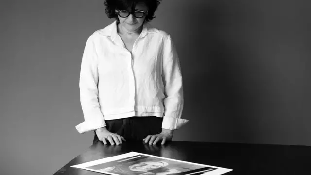 Iranian filmmaker and activist Sepideh Farsi looks at a portrait of the Palestinian photographer Fatima Hassouna, during a photo session at her home in Paris on May 5, 2025. 
