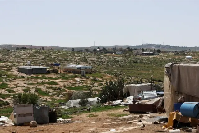 مستوطنة إسرائيلية تظهر في الخلفية، في سوسيا بالضفة الغربية التي تحتلها إسرائيل، 25 مارس/آذار 2025.