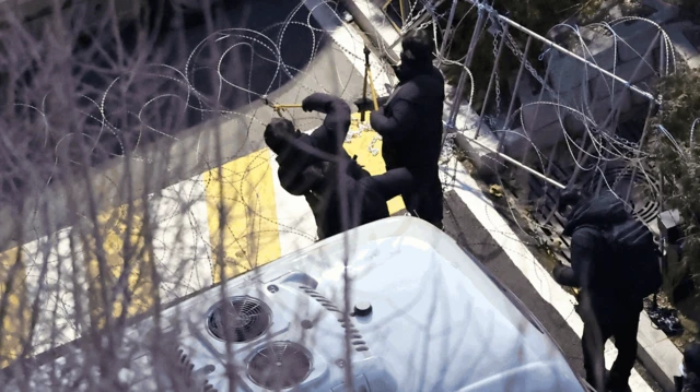 Policías cortando el alambre de púas en la residencia presidencial.