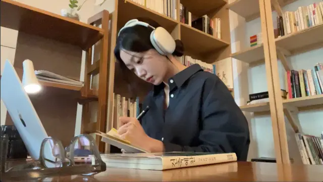 한 여성이 카페에서 공부를 하고 있다.