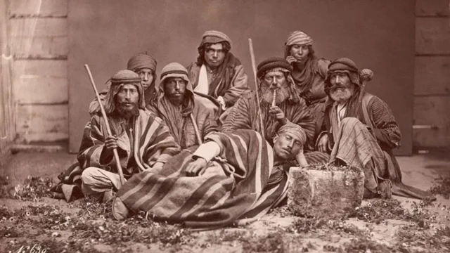 عکس قدیمی از چند نفر در یک عکس دست جمعی که جلوی دوربین ژست گرفته‌اند