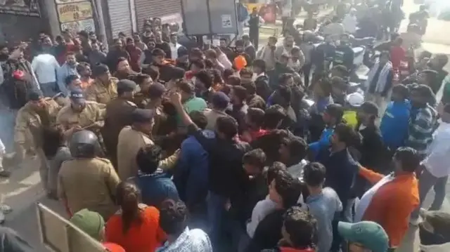 Protesters and police outside Deepak Kumar's gym in India's Kotdwar town