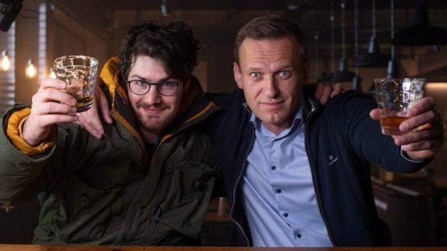 Daniel Roher y Alexei Navalny sostienen un vaso de whisky cada uno