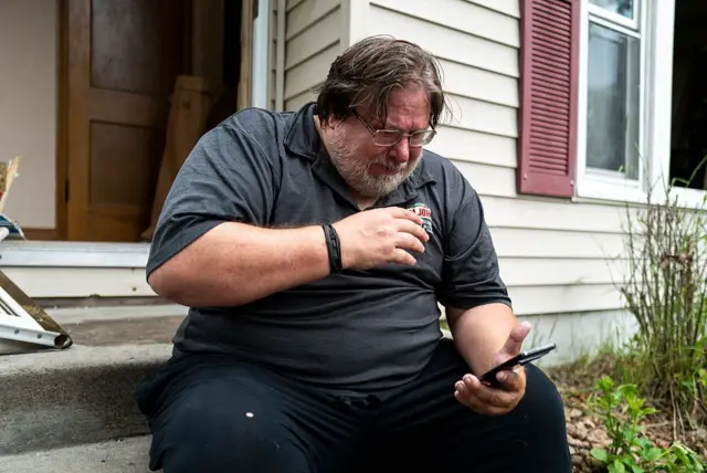 
David Carlson lê uma mensagem de texto que recebeu de Boelter em frente à sua casa, no dia 14 de junho de 2025, em Minneapolis, Minnesota.

