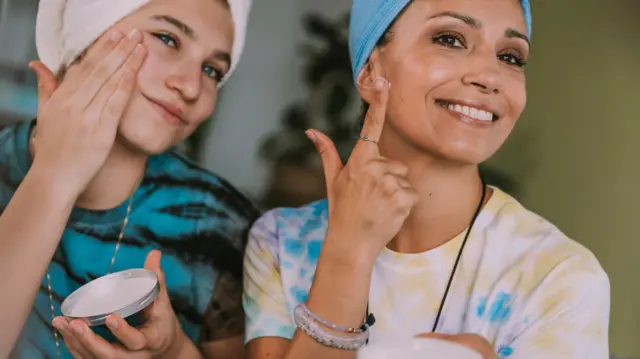 Dos jóvenes con cremas faciales. 