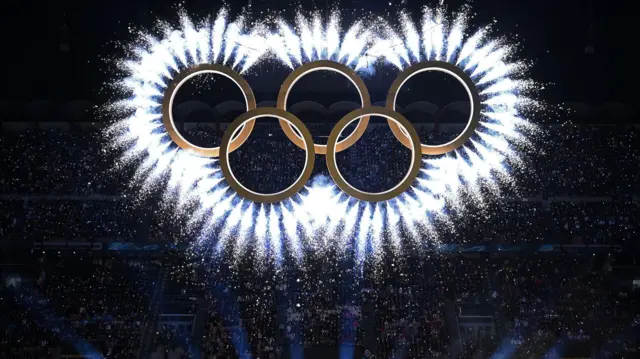 সান সিরোতে উদ্বোধনী অনুষ্ঠানের সময় অলিম্পিক রিং থেকে আতশবাজি ফুটে ওঠে