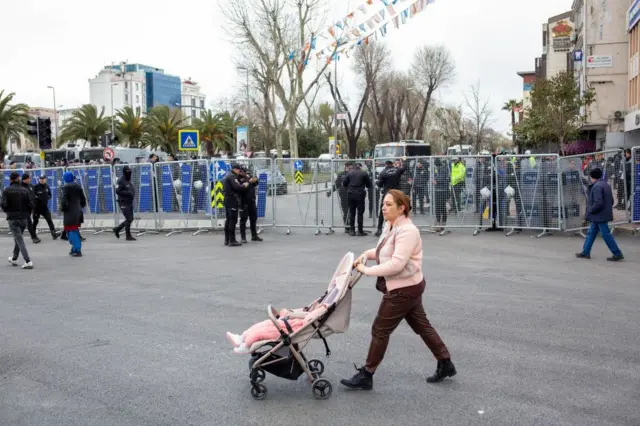 Vatan Caddesi'nde polis barikatları. Önde bir anne pusette bebeğiyle yürüyor.