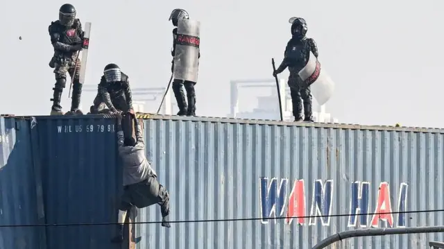 कंटेनर पर चढ़ने की कोशिश करता एक पीटीआई समर्थक