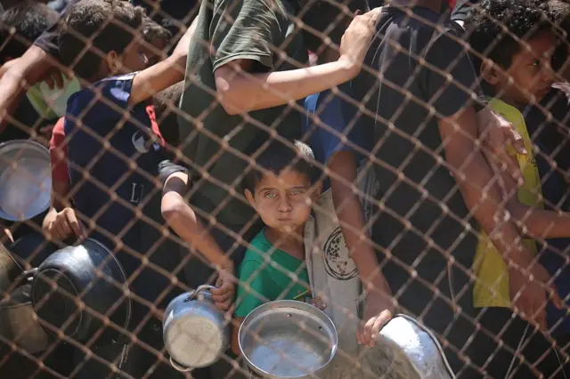 Una organización benéfica distribuye comida caliente a palestinos que enfrentan dificultades para acceder a los alimentos debido a los continuos ataques de Israel en la Franja de Gaza el 13 de julio de 2025.