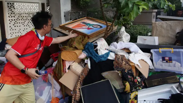 Pekerja mengumpulkan barang yang dikeluarkan dari rumah Menteri Keuangan Sri Mulyani oleh massa tidak dikenal di Bintaro, Tangerang Selatan, Banten, Minggu (31/8/2025).