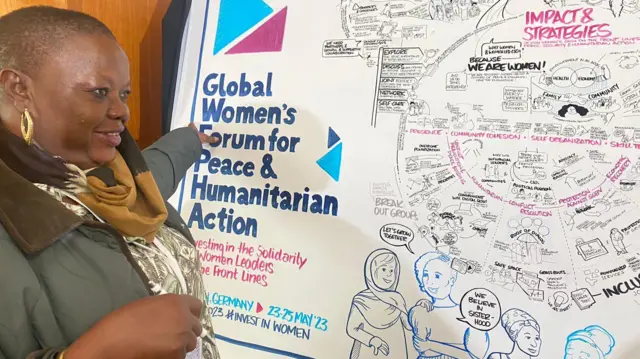 Miatta Gray points to a poster