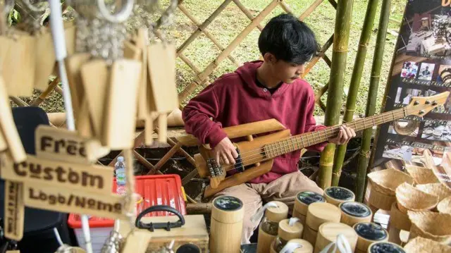 Perajin memainkan gitar dari bambu (Bambusoideae) saat pameran kerajinan Festival Sada Awi di Bandung, Jawa Barat, Rabu (04/12). 