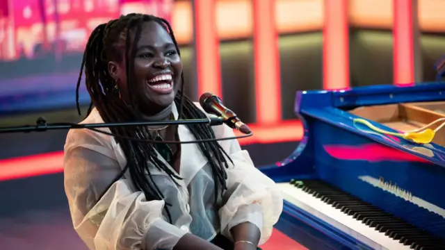 Daymé Arocena sentada frente a un piano.