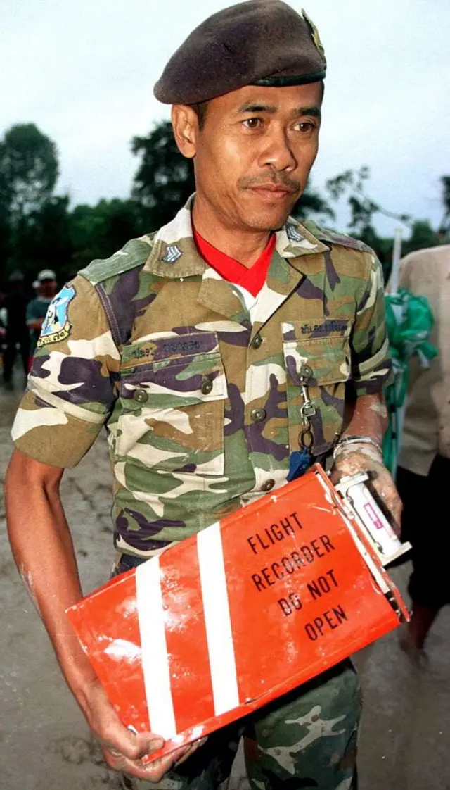 Tayland ordusundan bir asker üzgün bir şekilde karakutu taşıyor