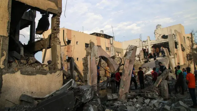 Palestinian emergency services and local citizens search for victims in buildings destroyed during Israeli raids in the southern Gaza Strip on October 17, 2023 in Khan Yunis, Gaza