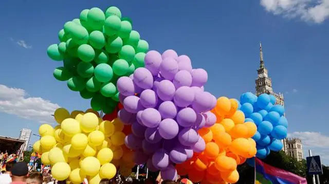 Uczestnicy parad Warsaw Pride i Kyiv Pride trzymają balony w kolorach tęczy, świętując na ulicach Warszawy 25 czerwca 2022 roku.