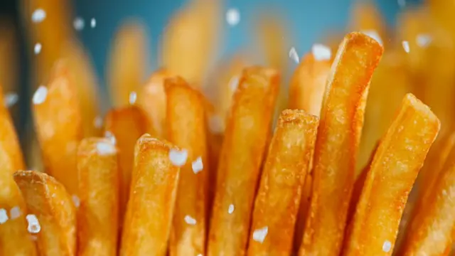 Papitas fritas con cristales de sal cayendo