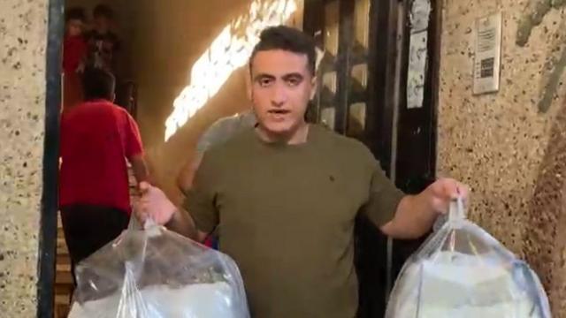 Abdelhakim segurando pacotes transparentes com alimentos
