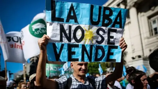 Homem segura um cartaz com os dizeres 'A UBA não se vende'