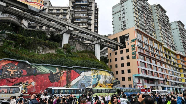 游客在中国西南的重庆拍摄列车进站的画面。