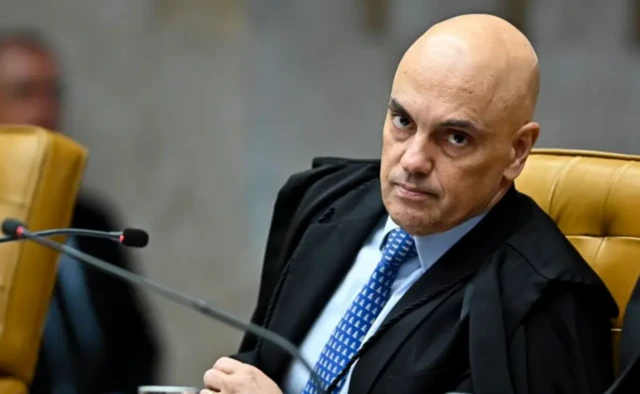 Alexandre de Moraes usando toga dentro do STF com a cabeça inclinada 