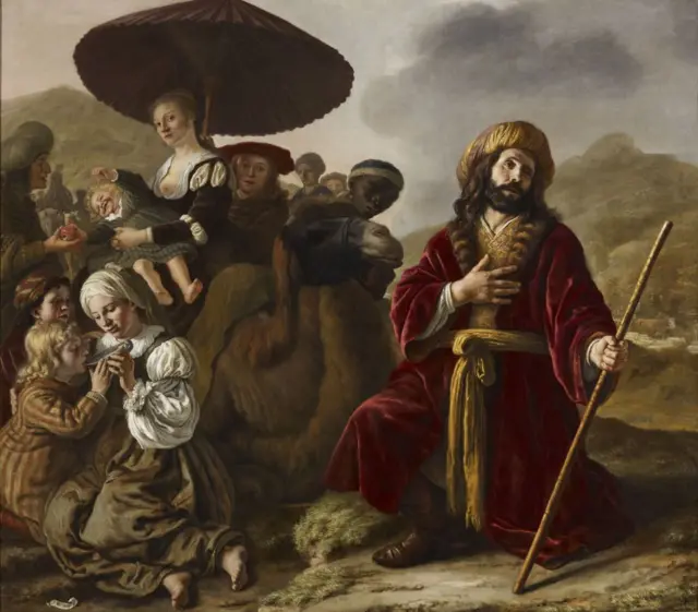 Jacob con turbante dorado y abrigo vinotinto con dorado, barba y cabello largo, arrodillado, con una mano en el pecho y en la otra asiendo un bastón. Al lado izquierdo se ven varias personas, y más claramente una mujer bajo una sombrilla cargando a un bebé y otra sentada en el piso en primer plano, alimentando a una niña. 