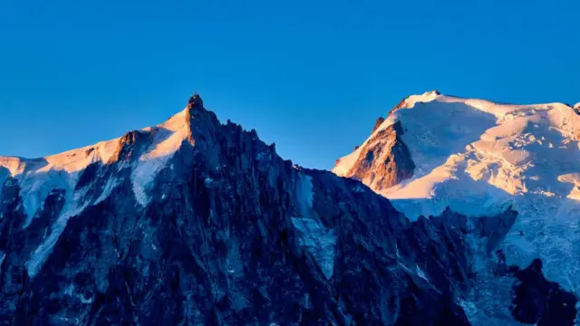 Puncak Aiguille du Midi dan Mont Blanc du Tacul, dari kiri, terlihat dari Le Brevent saat matahari terbit