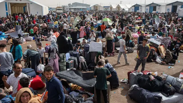 پناهجویان افغان که از ایران بازگردانده شدهاند، در نزدیکی گذرگاه اسلامقلعه نشستهاند. تاریخ: ۴ جولای ۲۰۲۵.
پس از آغاز جنگ ایران و اسرائیل، موج اخراجهای دستهجمعی افزایش یافت؛ مقامات ایرانی افغانها را به جاسوسی متهم کرده و روزانه هزاران نفر را دیپورت میکنند.